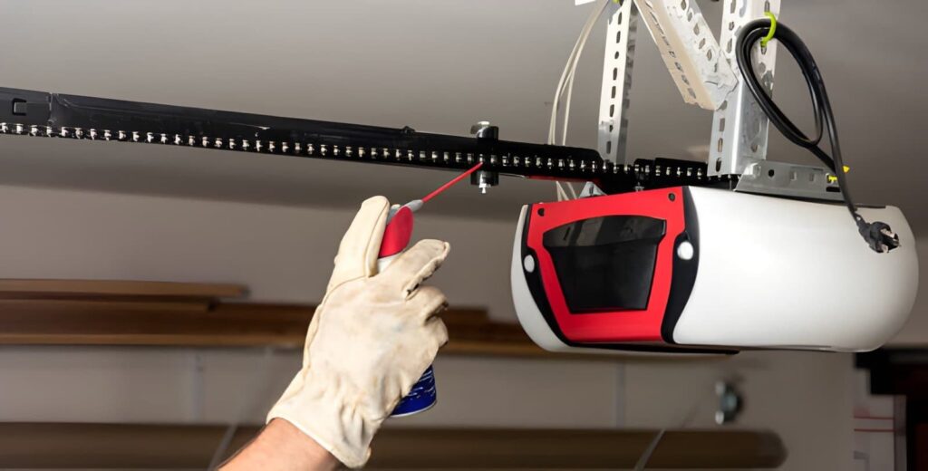 Garage door technician spraying railing with oil to repair garage door opener issue