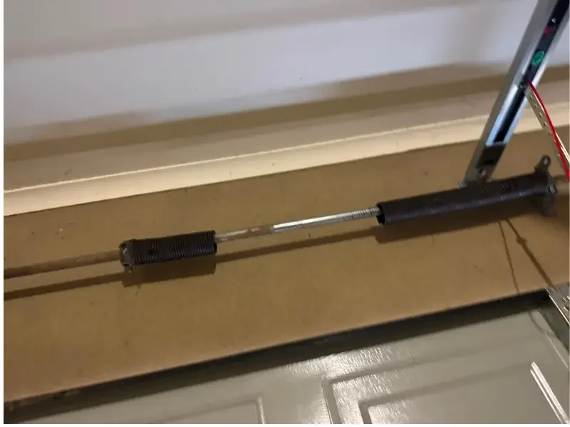 this is an image of broken torsion spring of garage door